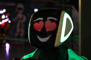 An AI robot with a face and hearts on it.