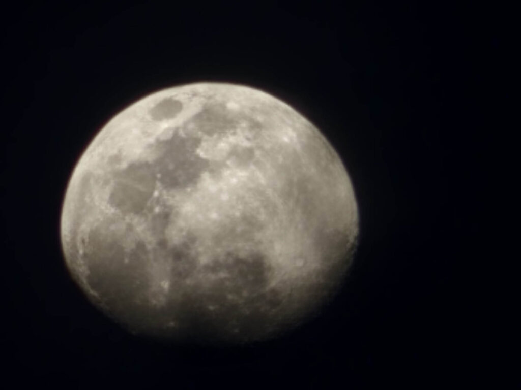 A full moon is seen in the dark sky on television.